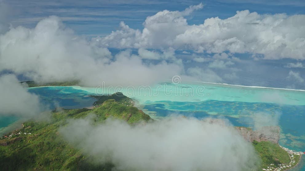 Tj Hartman Net Worth – Bora bora lagoon emerging from clouds, french polynesia stock image