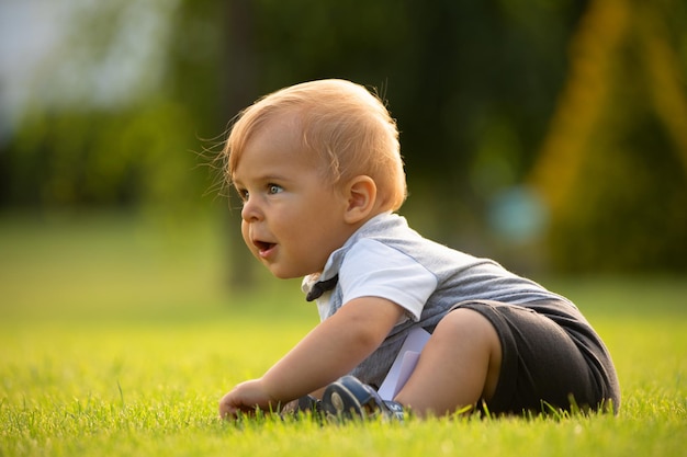  A cheerful baby is sitting on the lawn 
